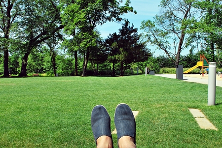 Legs in shoes on green grass backgroundの写真素材