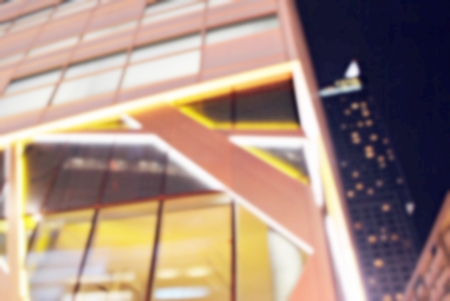 Blurred night skyscrapers with glass facade. Modern buildings