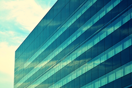 Modern office building facade abstract fragment, shiny windows in steel structure, retro stylized colorful tonal filter effectの写真素材