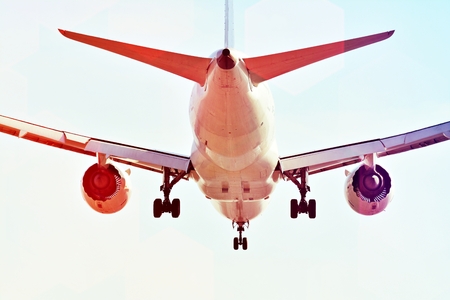 Airplane on the blue sky. A passenger plane is flying from the runway in the sun.