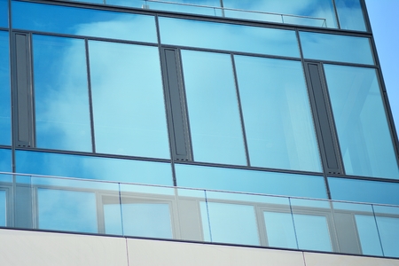 Abstract fragment of contemporary architecture, walls made of glass and concrete. Glass curtain wall...