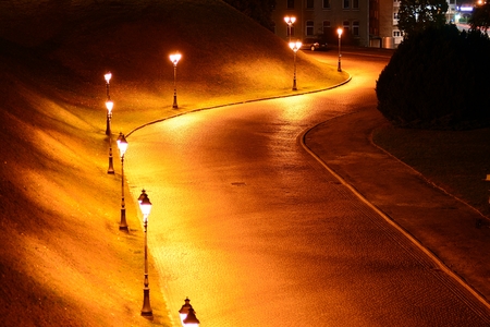 Curvy road in the city at night. Night street and yellow lights.の写真素材