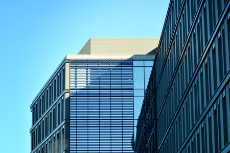Modern office building facade abstract fragment, shiny windows in steel structure.