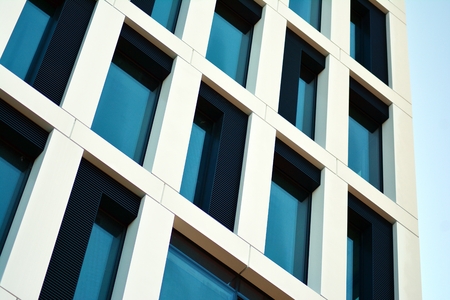 View of modern skyscrapers in business district against blue sky