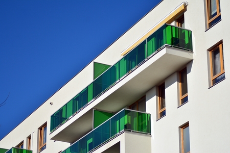 Fragment of a building with windows and balconies. Modern home with many flats.の写真素材