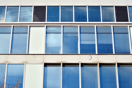 Facade fragment of a modern office building. Exterior of glass wall with abstract texture.