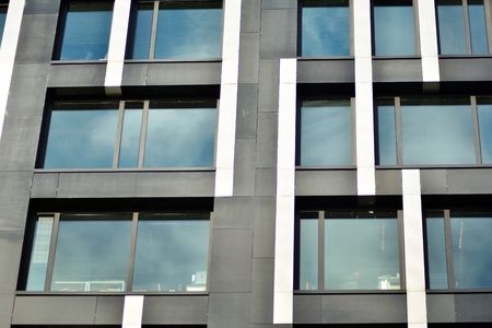 Facade fragment of a modern office building. Exterior of glass wall with abstract texture.