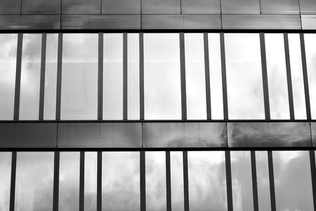 Modern building with reflected sky and cloud in glass window. Black and white.の写真素材