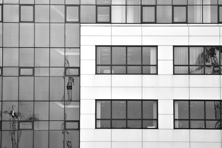 Modern building with reflected sky and cloud in glass window. Black and white.の写真素材