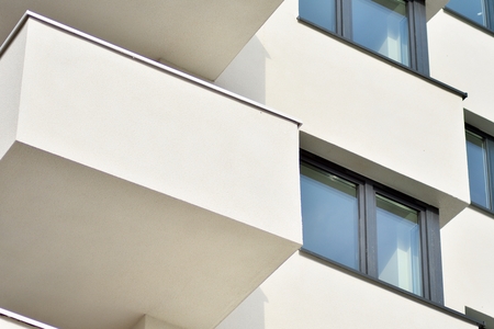 Modern white building with balcony on a blue skyの写真素材