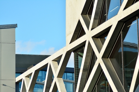 Abstract image of looking up at modern glass and concrete building. Architectural exterior detail of...