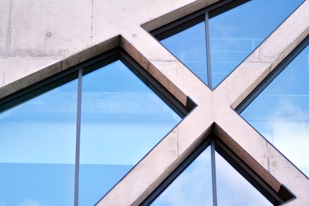 Abstract image of looking up at modern glass and concrete building. Architectural exterior detail of office building.の写真素材