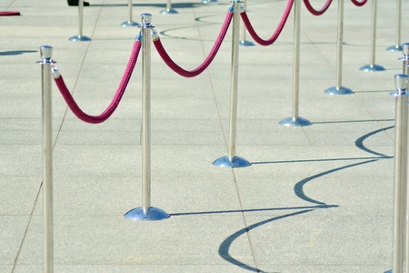 Silver stanchions with a purple rope.