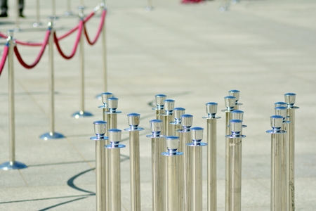 Silver stanchions with a purple rope.