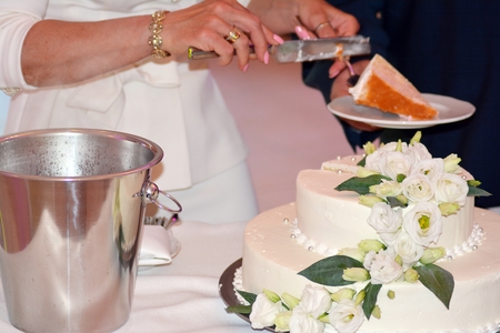 A bride and a groom is cutting their wedding cakeの写真素材