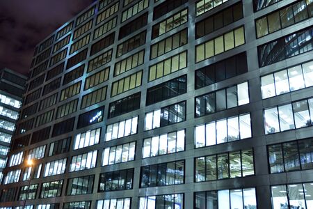 Pattern of office buildings windows illuminated at night. Lighting with Glass architecture facade...