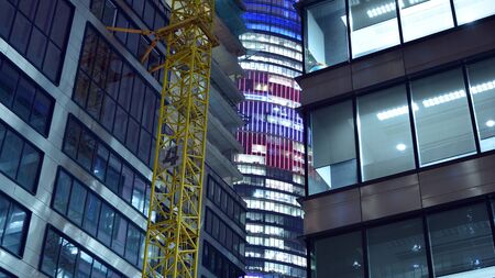 Pattern of office buildings windows illuminated at night. Lighting with Glass architecture facade...