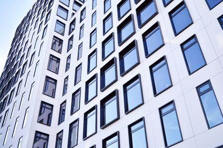 Modern European building. White building with many windows against the blue sky. Abstract...
