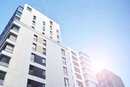 Modern apartment buildings on a sunny day with a blue sky. Facade of a modern apartment building. Glass surface with sunlight.の写真素材
