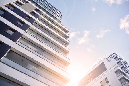 Sun rays light effects on urban buildings. Fragment of modern residential apartment with flat buildings exterior.の写真素材