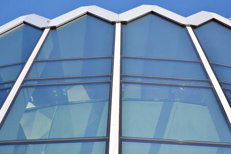 Abstract image of looking up at modern glass and concrete building. Architectural exterior detail of...