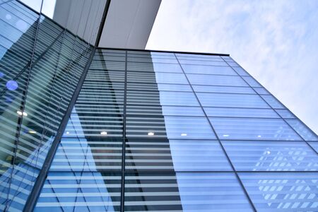 Abstract image of looking up at modern glass and concrete building. Architectural exterior detail of...