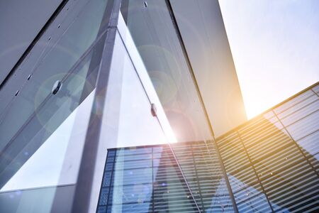 Sun rays light effects on urban buildings. Abstract image of looking up at modern glass and concrete...