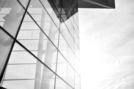 Sun rays light effects on urban buildings in sunset. Modern office building detail, glass surface with sunlight. Business background. Black and white.の写真素材