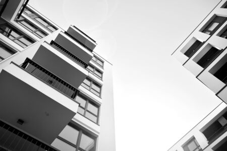 Sun rays light effects on urban buildings. Fragment of modern residential apartment with flat buildings exterior. Detail of new luxury house and home complex. Black and white.の写真素材
