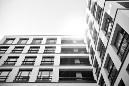 Sun rays light effects on urban buildings. Fragment of modern residential apartment with flat buildings exterior. Detail of new luxury house and home complex. Black and white.の写真素材