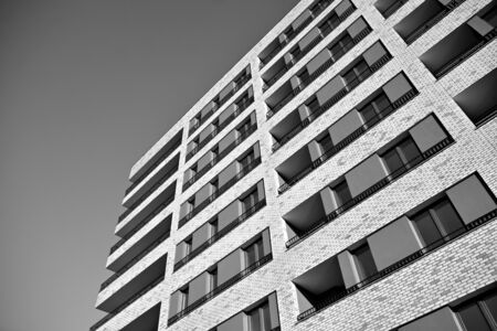 Sun rays light effects on urban buildings. Fragment of modern residential apartment with flat buildings exterior. Detail of new luxury house and home complex. Black and white.の写真素材