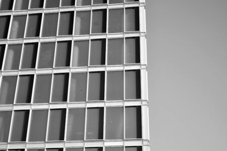Sun rays light effects on urban buildings in sunset. Modern office building detail, glass surface with sunlight. Business background. Black and white.の写真素材