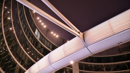 Night architecture - building with glass facade. Modern building in business district. Concept of economics, financial. Photo of commercial office building exterior. Abstract image of office buildingの写真素材