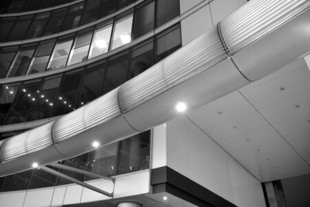 Night architecture - building with glass facade. Business district. Concept of economics, financial. Photo of commercial office building exterior. Abstract image of office building. Black and white.の写真素材