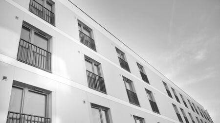 Sun rays light effects on urban buildings. Fragment of modern residential apartment with flat buildings exterior. Detail of new luxury house and home complex. Black and white.の写真素材