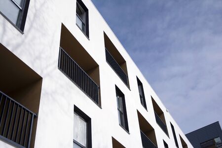 Exterior of new apartment buildings on a blue cloudy sky background. No people. Real estate business...