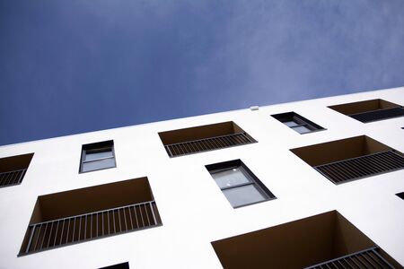 Exterior of new apartment buildings on a blue cloudy sky background. No people. Real estate business...
