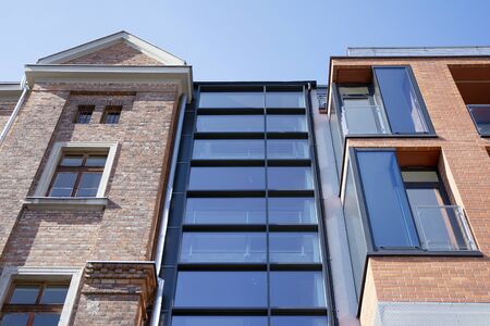 Exterior of new apartment buildings on a blue cloudy sky background. No people. Real estate business concept.の写真素材