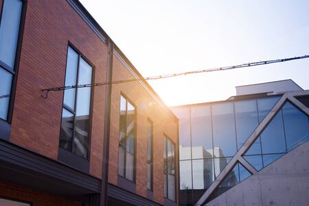 Office building glass facades on a bright sunny day with sunbeams in the blue sky. Abstract view of...