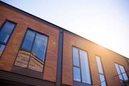 Office building glass facades on a bright sunny day with sunbeams in the blue sky. Abstract view of...
