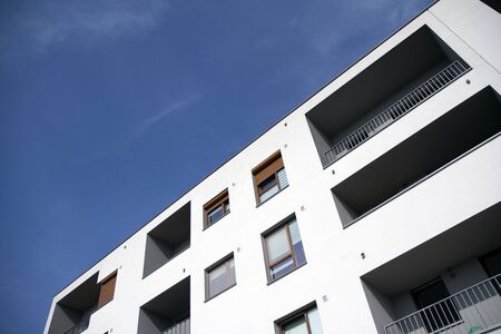 Exterior of new apartment buildings on a blue cloudy sky background. No people. Real estate business...