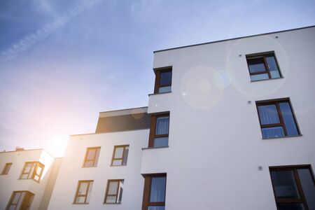 Exterior of new apartment buildings on a blue cloudy sky background. No people. Real estate business concept.の写真素材