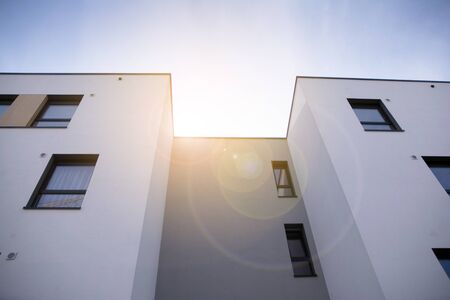 Exterior of new apartment buildings on a blue cloudy sky background. No people. Real estate business...