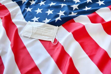 Protective surgical face mask on American national flag. Coronavirus in USA Fllag with protective...