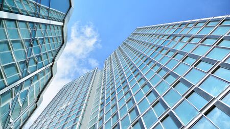 Structural glass wall reflecting blue sky. Abstract modern architecture fragment. View of a modern...