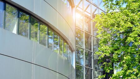 Glass building with blue sky background. Modern office building detail, glass surface clouds...