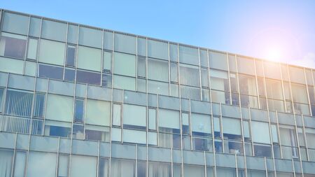 Glass building with blue sky background. Modern office building detail, glass surface clouds...