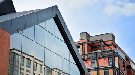 Structural glass wall reflecting blue sky. Abstract modern architecture fragment. View of a modern...