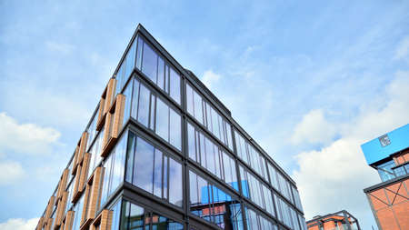 Structural glass wall reflecting blue sky. Abstract modern architecture fragment. View of a modern glass skyscraper, modern office building. Modern office facade fragment with blue glass.のeditorial素材