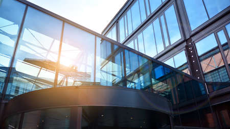 Bottom view of office building window close up with sunrise, reflection and perspective. Modern...